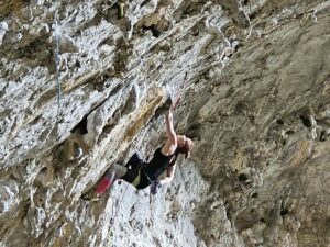 Mojca Bizjak climbing Active discharge (8a) in the big cave of Osp